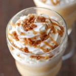 A glass holding cinnamon streusel coffee cake frappe topped with whipped cream and caramel.