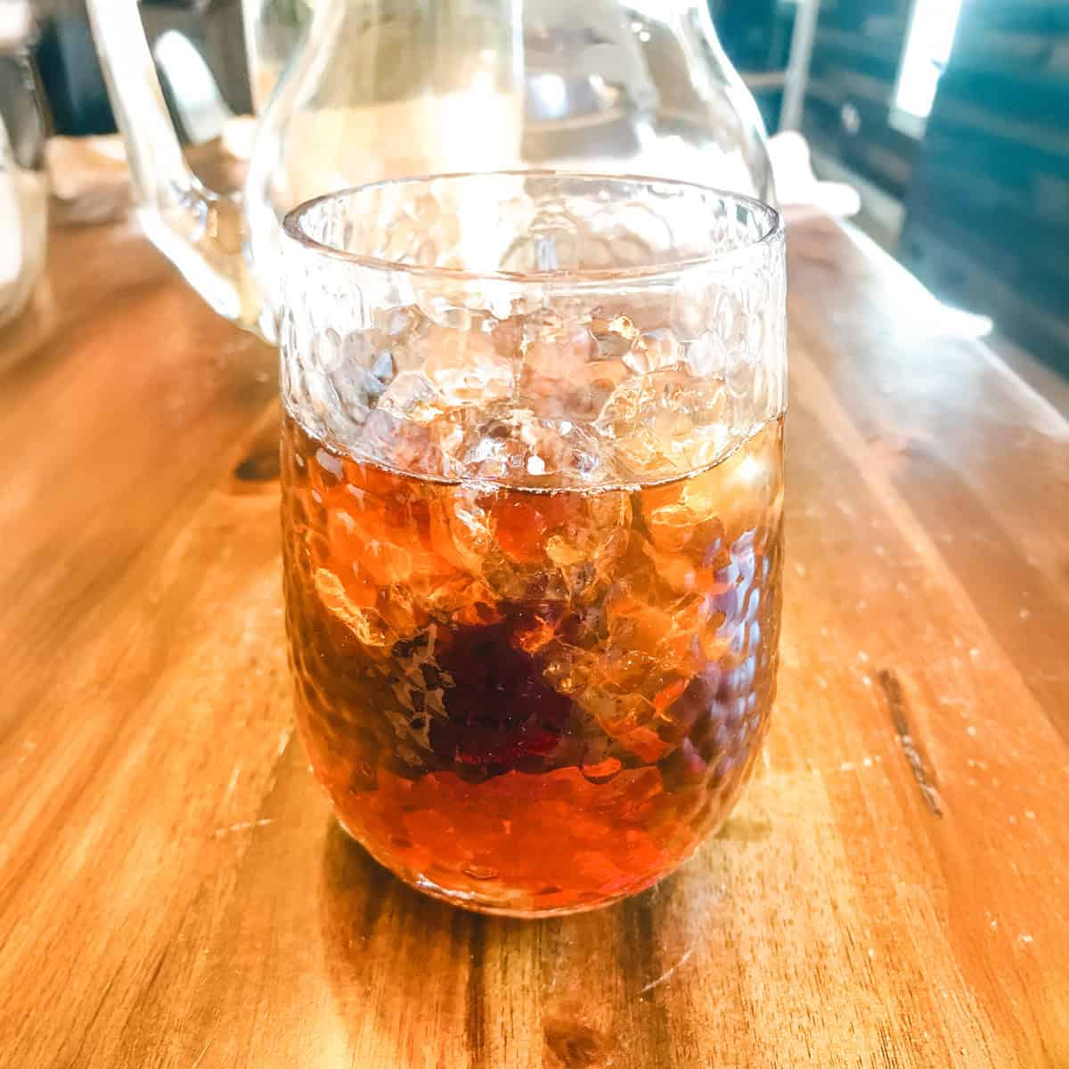 Sweet tea in a glass on a wood table.