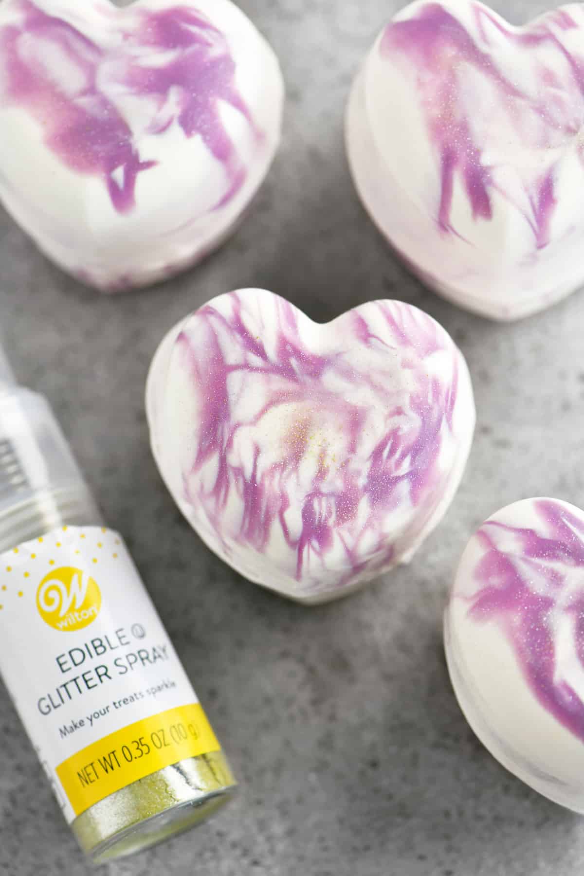 edible glitter spray on purple and white swirled breakable chocolate hearts