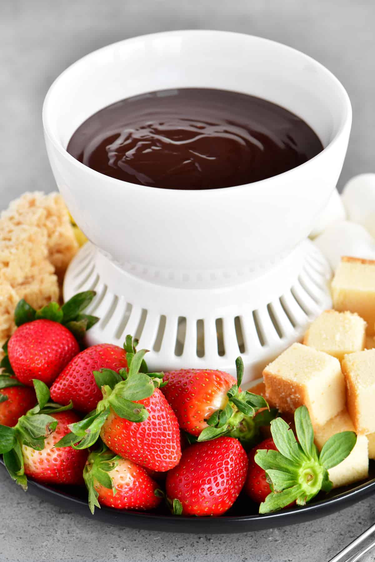 A fondue tray with strawberries and pound cake for dipping in chocolate.