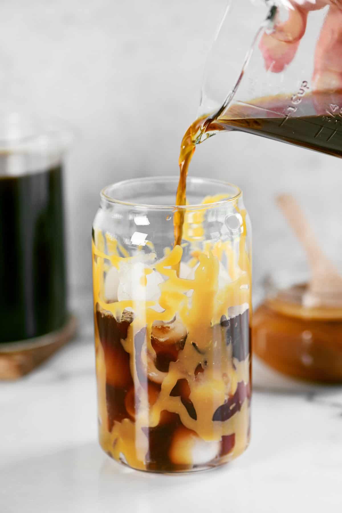 https://www.thegunnysack.com/wp-content/uploads/2022/05/Iced-Caramel-Cold-Brew-Coffee-Pour.jpg