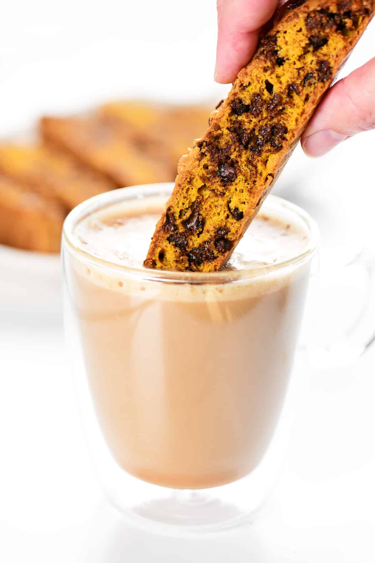 Dunking pumpkin biscotti in a cup of coffee.