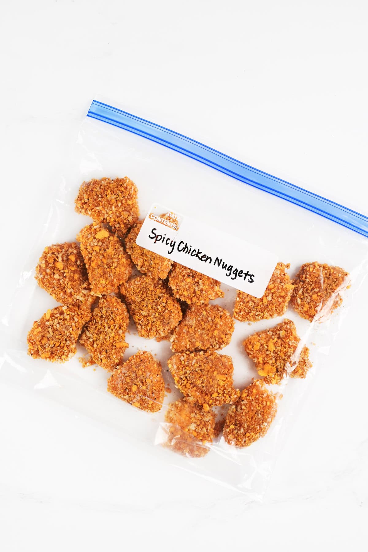 Spicy chicken nuggets in a labeled gallon sized ziptop bag.