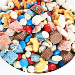 Red white and blue trail mix in a white bowl.