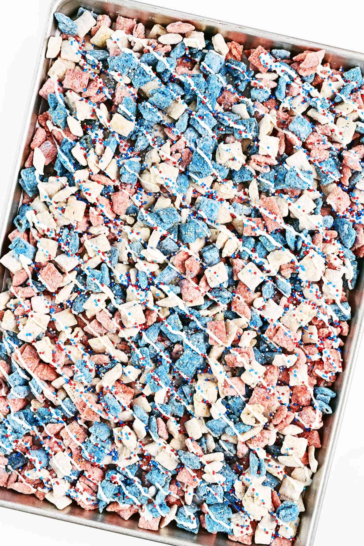 Red white and blue puppy chow on a baking sheet.