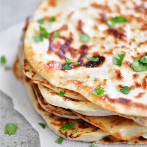 Stack of two ingredient dough naan flatbread with chopped cilantro.