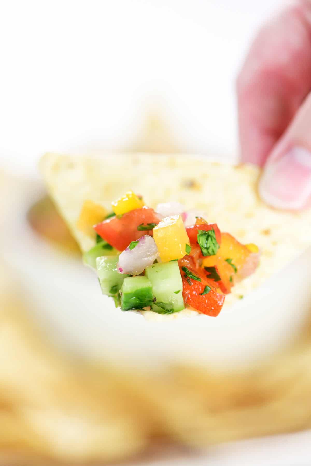 Peach salsa on a tortilla chip.