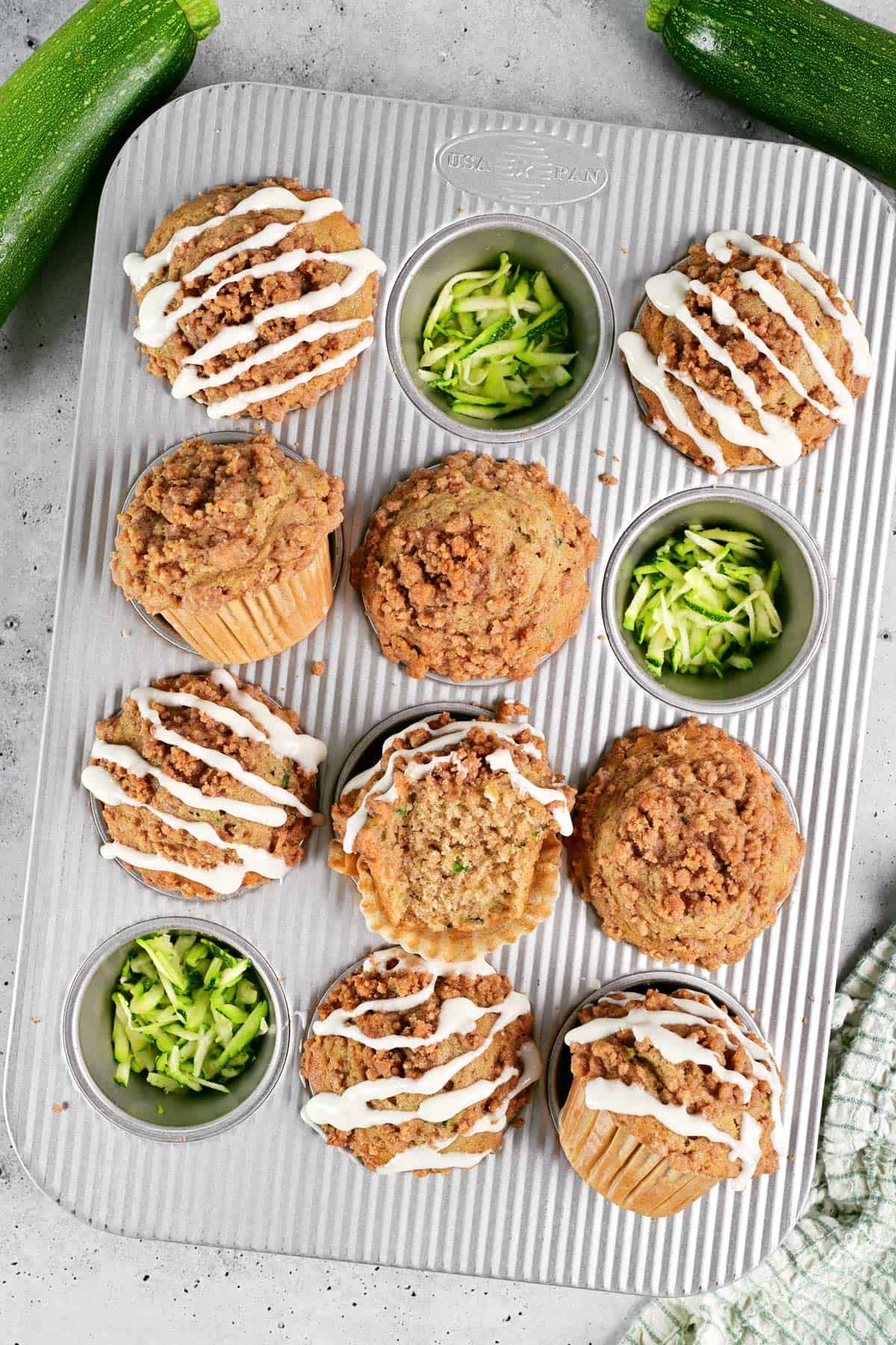 Zucchini muffins and shredded zucchini in a muffin pan.