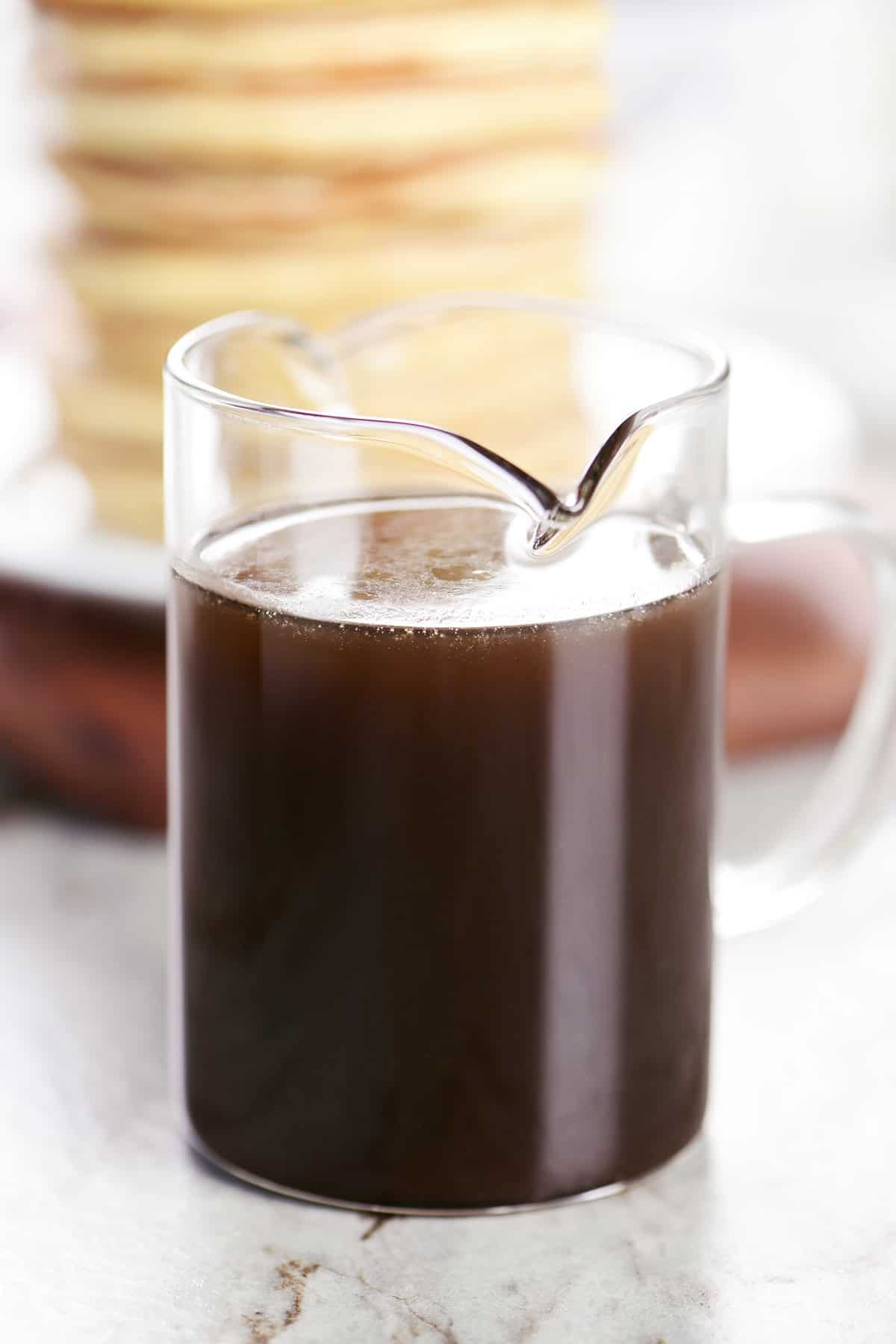 Homemade maple syrup in a glass pitcher.