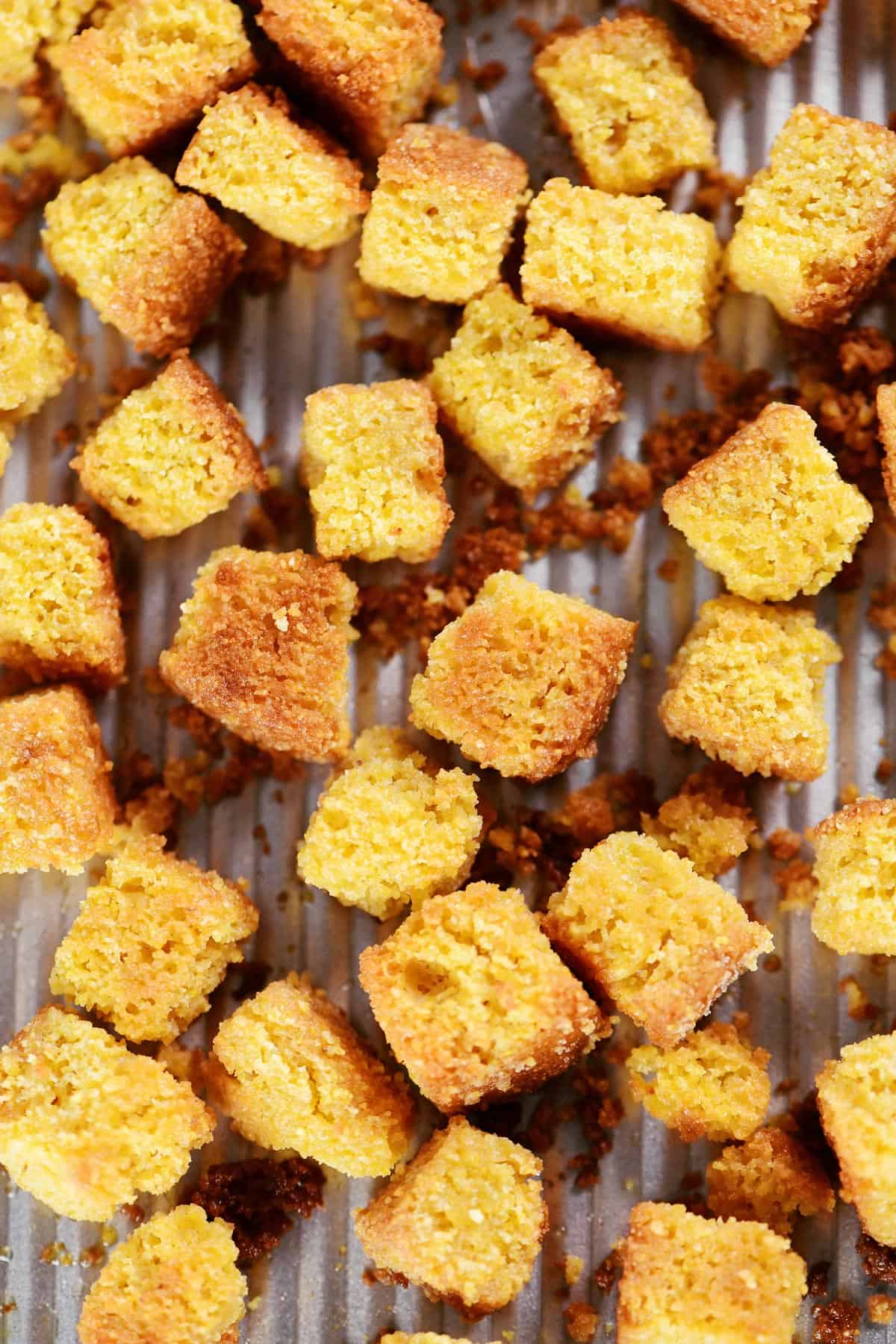 Cornbread croutons on a baking sheet.