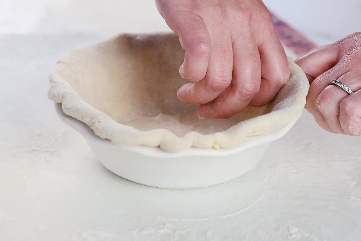 Fluting the edge of a pie crust.