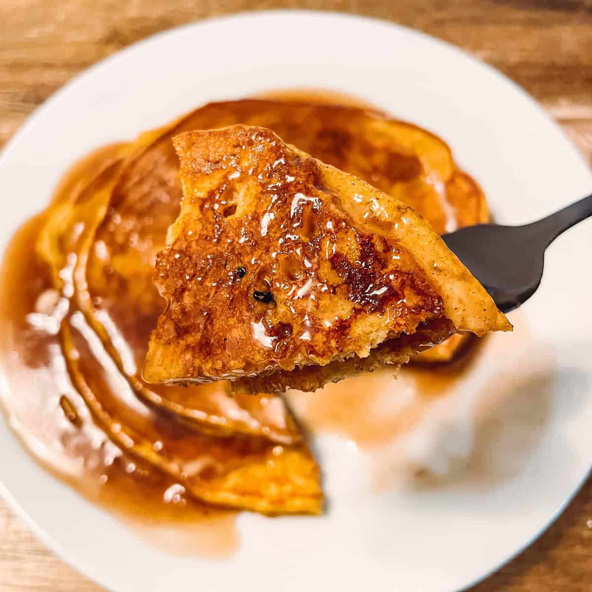 Bite of pumpkin pancakes on fork.