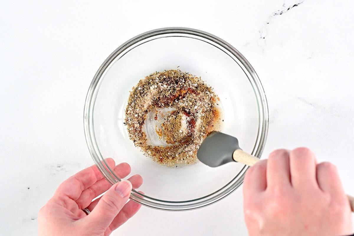 Stirring the seasonings in a small glass bowl.