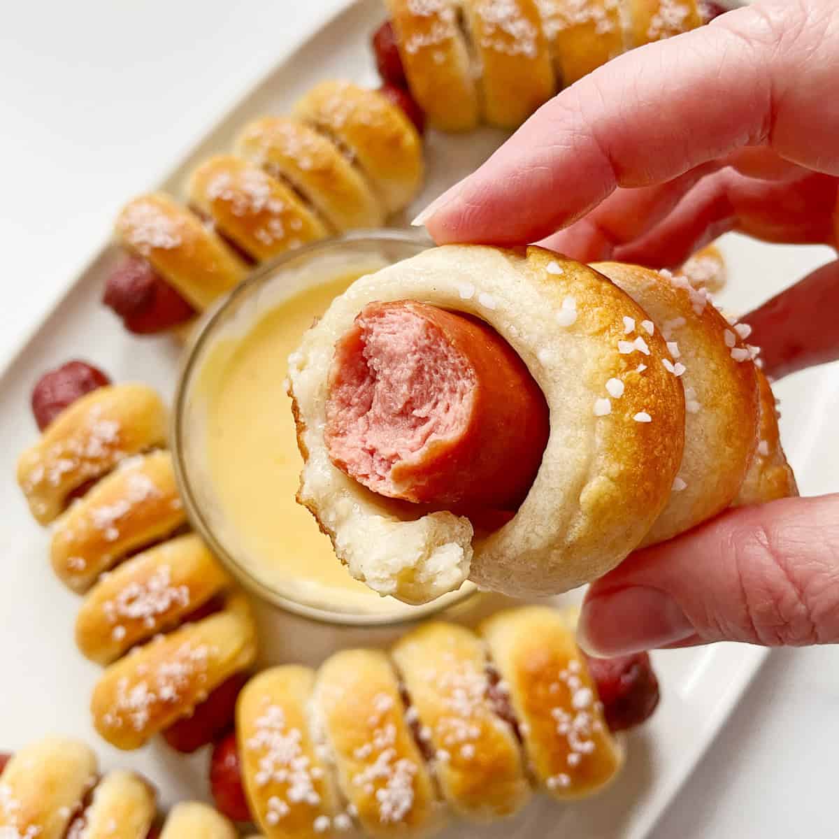 Tonia Larson holding a pretzel dog.