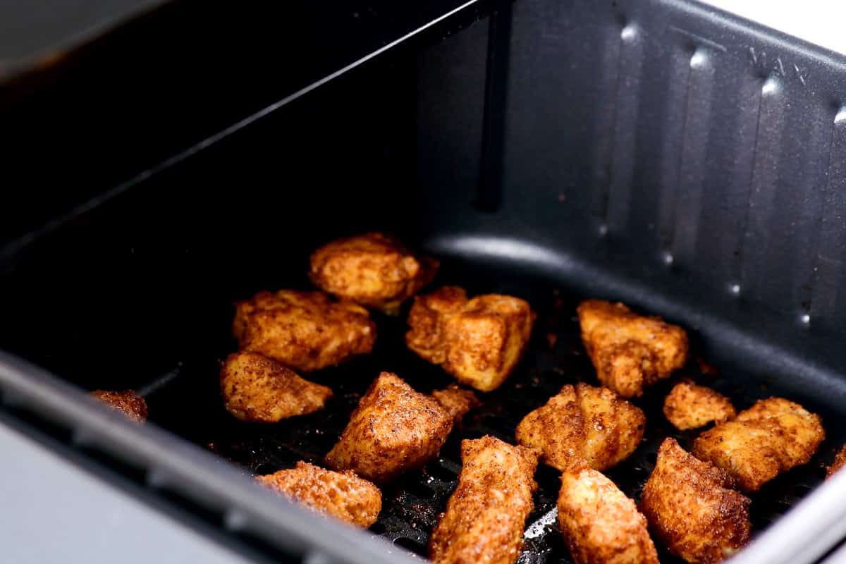 Sizzling chicken bites in air fryer.