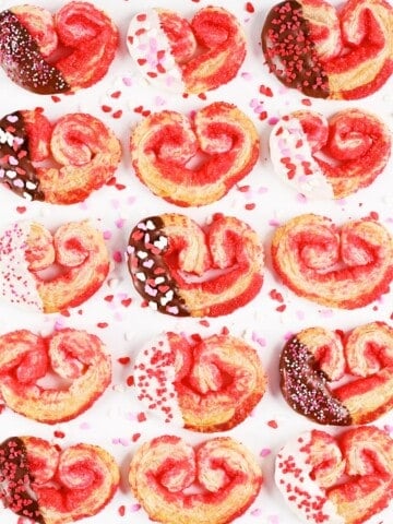 Puff pastry cookies heart shaped palmiers with chocolate and sprinkles.