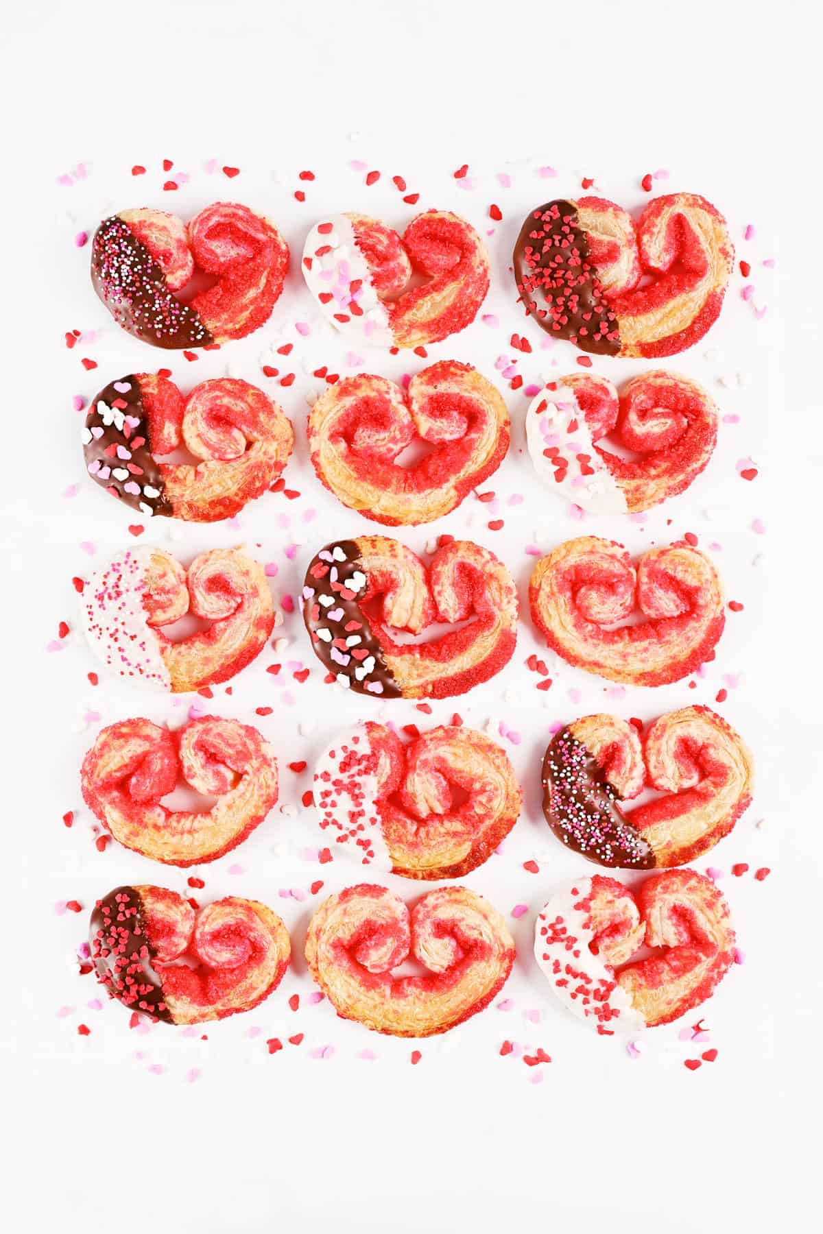 Puff pastry cookies heart shaped palmiers with chocolate and sprinkles.