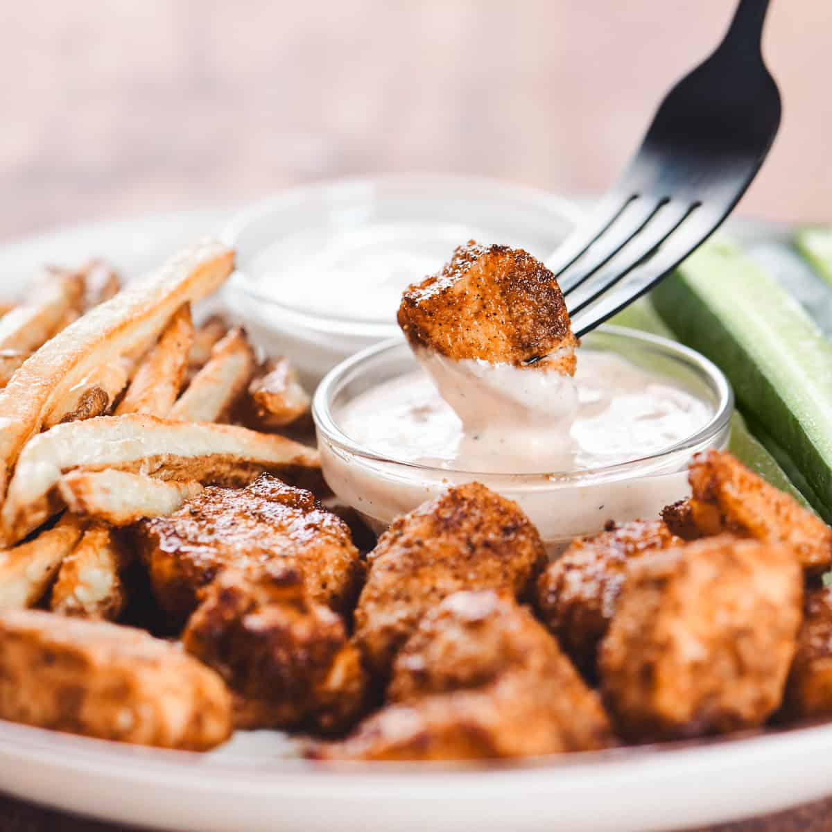 Dipping a chicken bite in sauce.