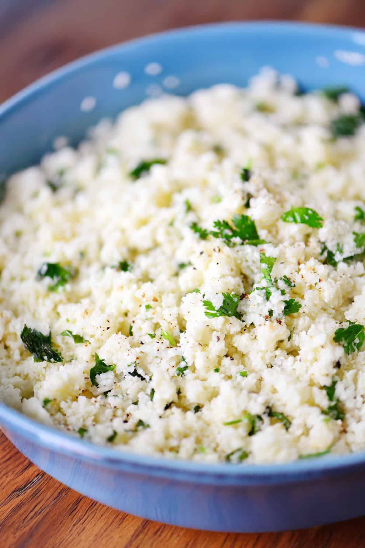 Cauliflower rice with cilantro in a blue bowl.