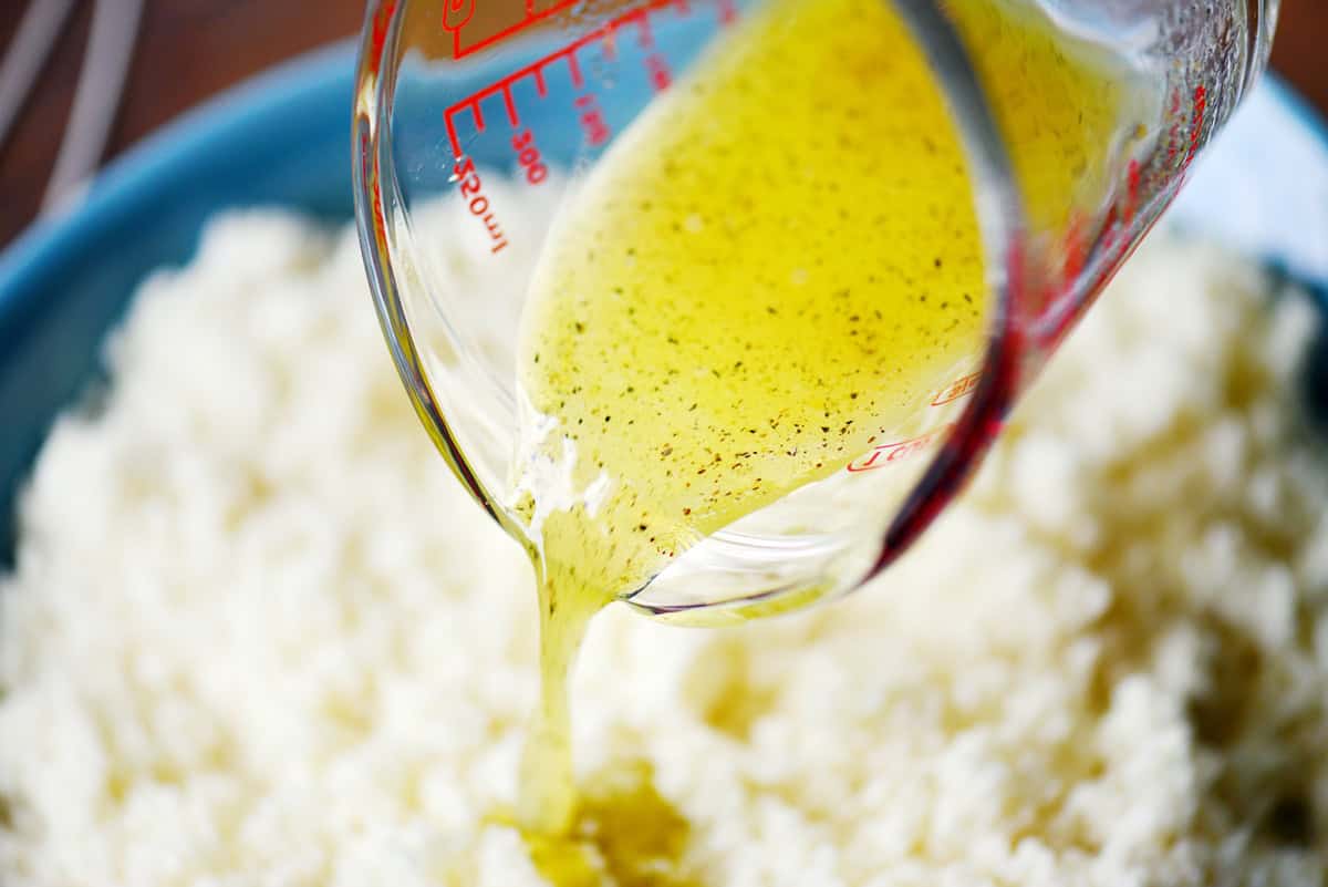 Pouring the olive oil mixture over the top.