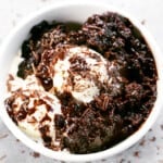 Slow cooker chocolate pudding cake in a bowl with vanilla ice cream.